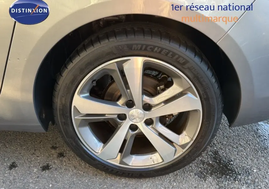 Gros plan sur la roue avant gauche d'une Peugeot 308 SW gris Artense métal avec jante alliage 17 pouces biton.