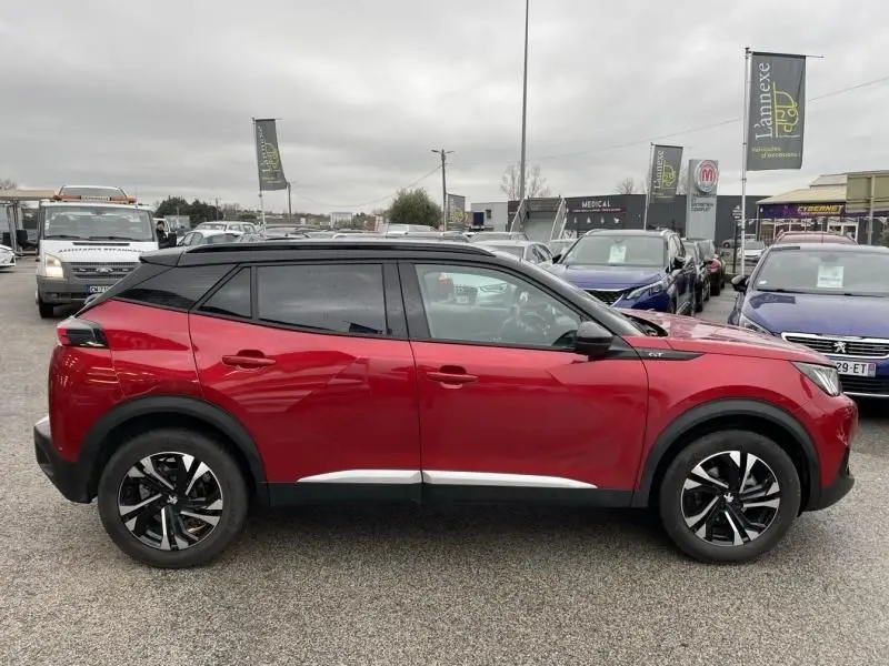 Profil côté gauche du Peugeot 2008 130 GT-LINE 2022 en rouge métal avec toit noir et jantes distinctives.