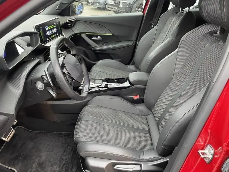 Vue intérieure côté conducteur du Peugeot 2008 130 GT-LINE rouge métal 2022, avec sièges en cuir et tableau de bord moderne.