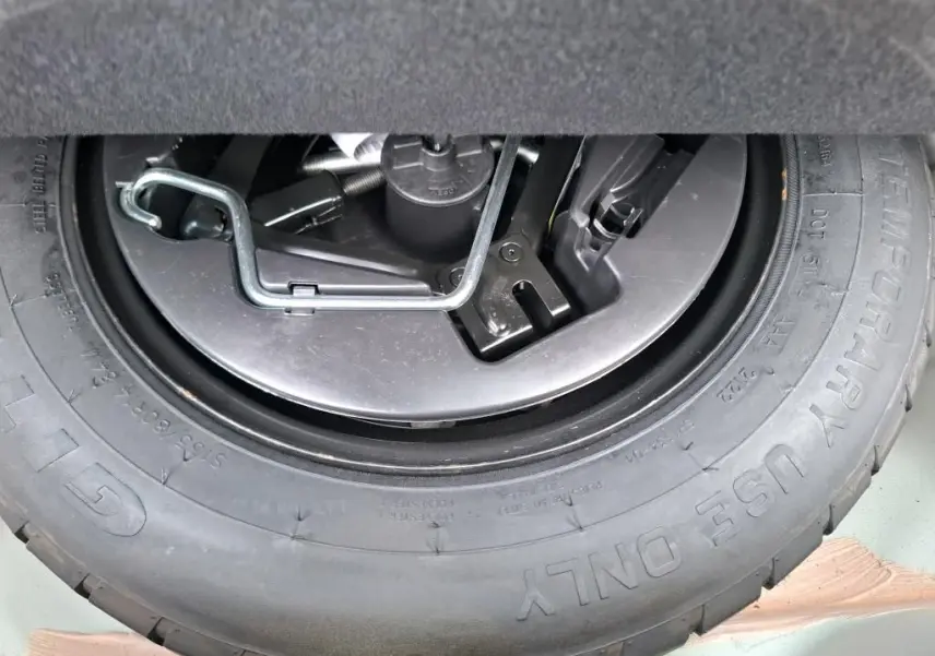 Gros plan sur la roue de secours et les outils de bord du coffre d'une FIAT 500 blanche Bossa Nova 2022.