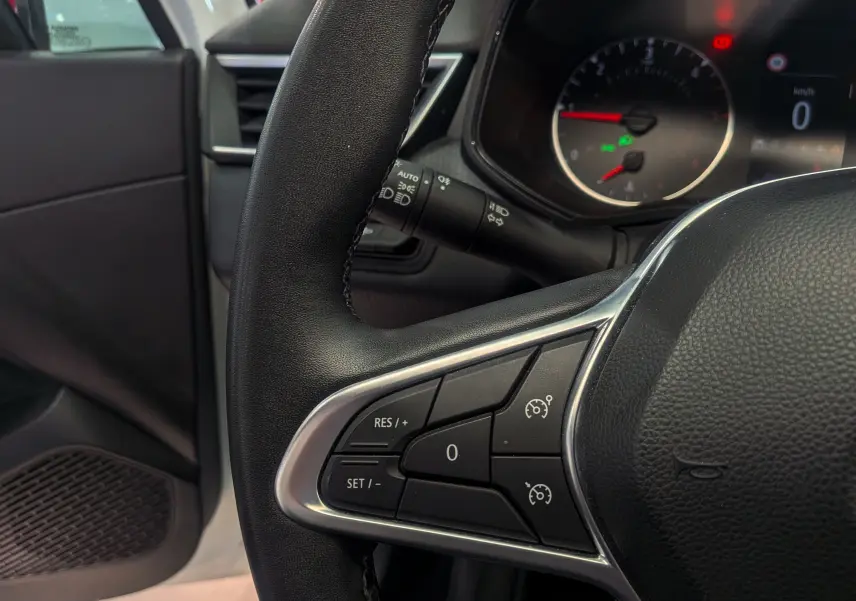Gros plan sur le volant côté gauche de la Renault Clio V Business 2021, avec commandes de régulateur de vitesse visibles.