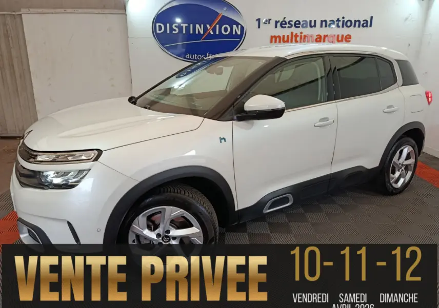 Vue 3/4 avant droit d’un Citroën C5 Aircross Hybrid blanc, avec jantes alliage et détails noirs contrastants.