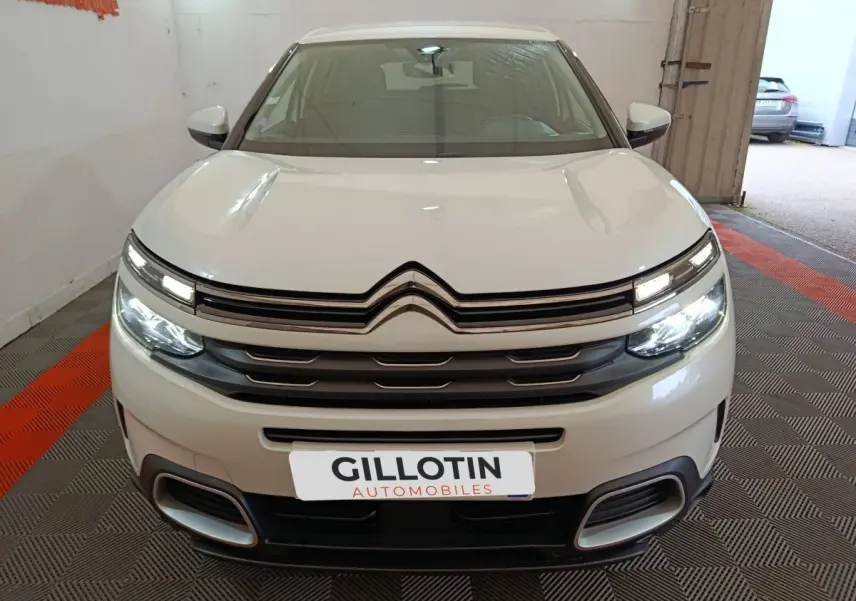 Vue de face du Citroën C5 Aircross blanc avec phares LED allumés et calandre distinctive en double chevron.