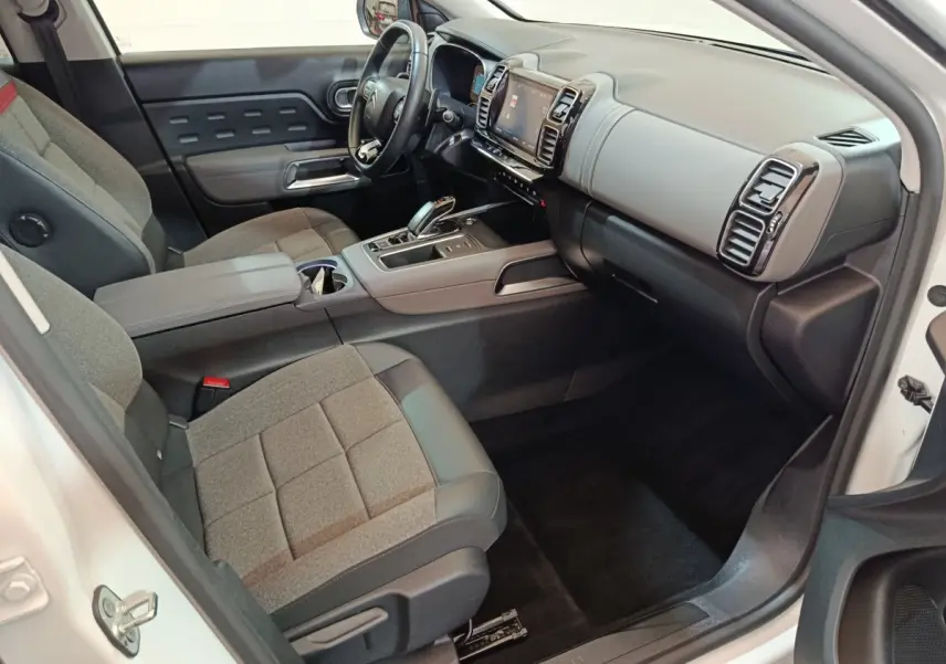 Intérieur côté passager du Citroën C5 Aircross Hybrid blanc, montrant sièges gris, tableau de bord et console centrale moderne.