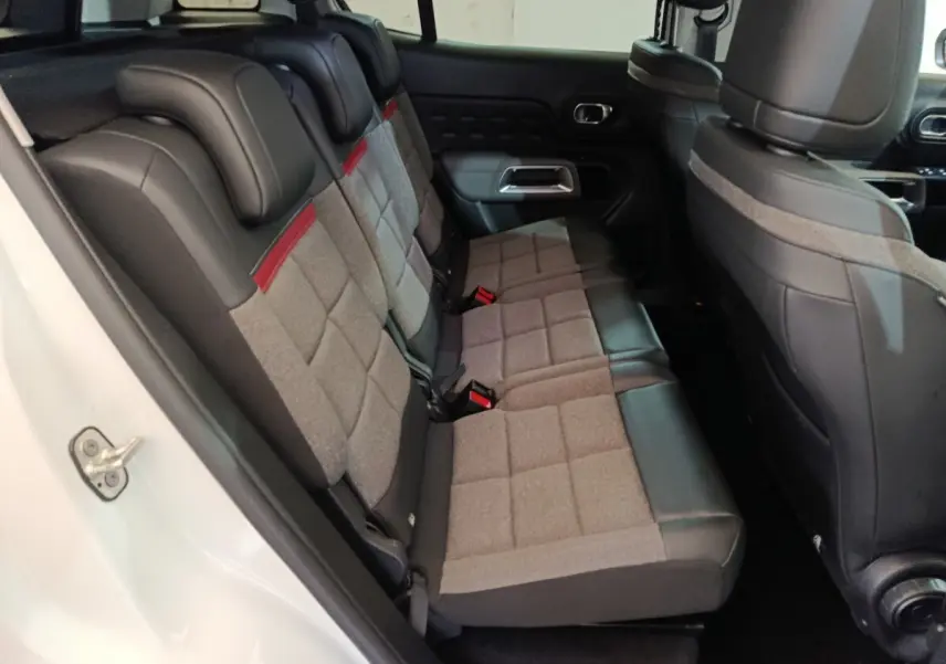 Vue intérieure côté gauche des sièges arrière gris et noirs avec surpiqûres rouges du Citroën C5 Aircross Hybrid blanc 2021.