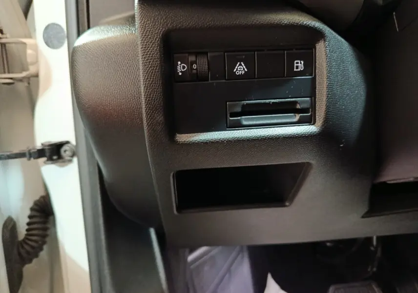 Détail intérieur côté gauche du tableau de bord noir du Citroën C5 Aircross Hybrid blanc, avec commandes d’éclairage et aide à la conduite.