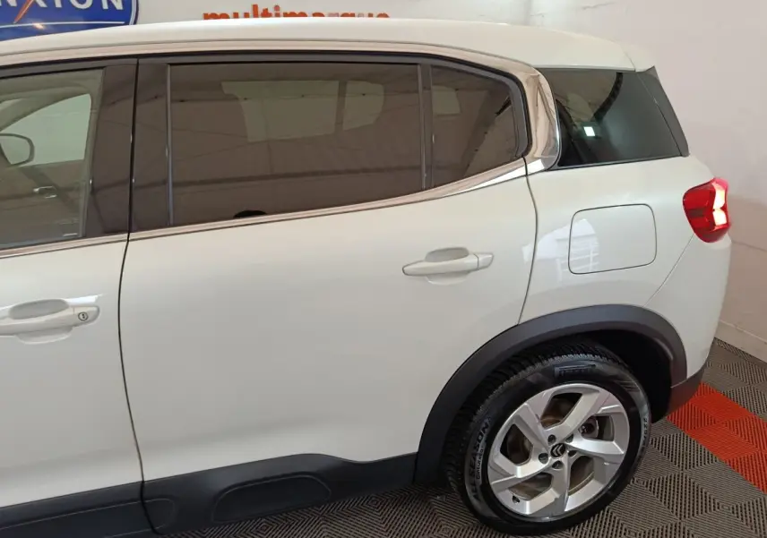 Vue latérale droite du Citroën C5 Aircross blanc hybride, mettant en valeur les vitres teintées et la jante alliage arrière.