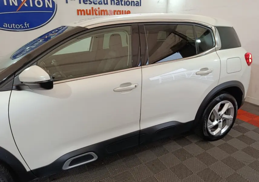 Vue latérale droite d'un Citroën C5 Aircross Hybrid blanc avec jantes alliage et protections noires basses.