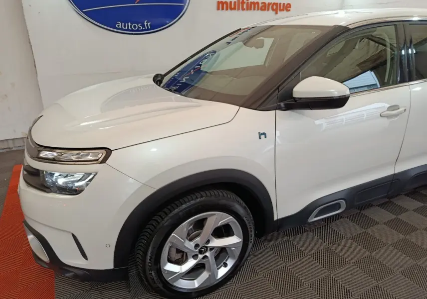 Vue 3/4 avant droit d'une Citroën C5 Aircross Hybrid blanche avec jantes alliage et détails noirs contrastants.