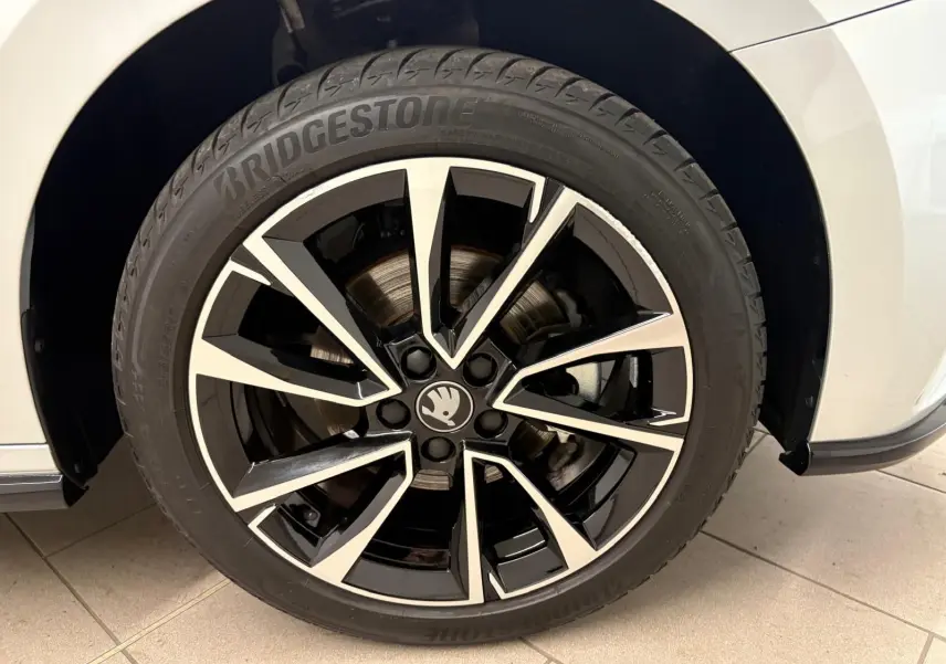 Gros plan sur la roue avant droite d'une Skoda Fabia gris argent avec jante alliage noire et argentée.