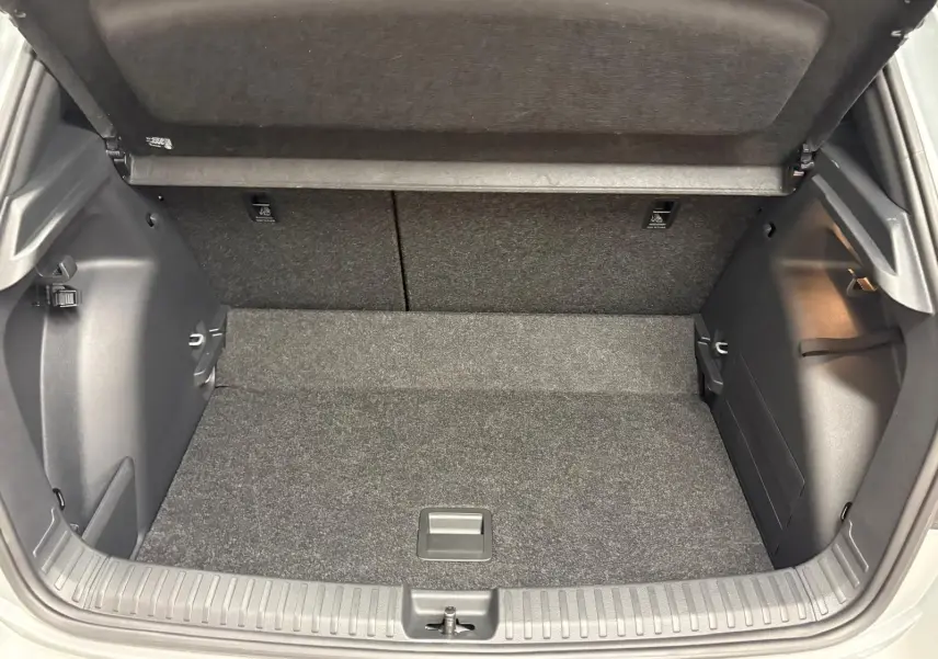Vue intérieure du coffre ouvert de la Skoda Fabia 2025, montrant le double plancher variable et la finition en tissu gris.