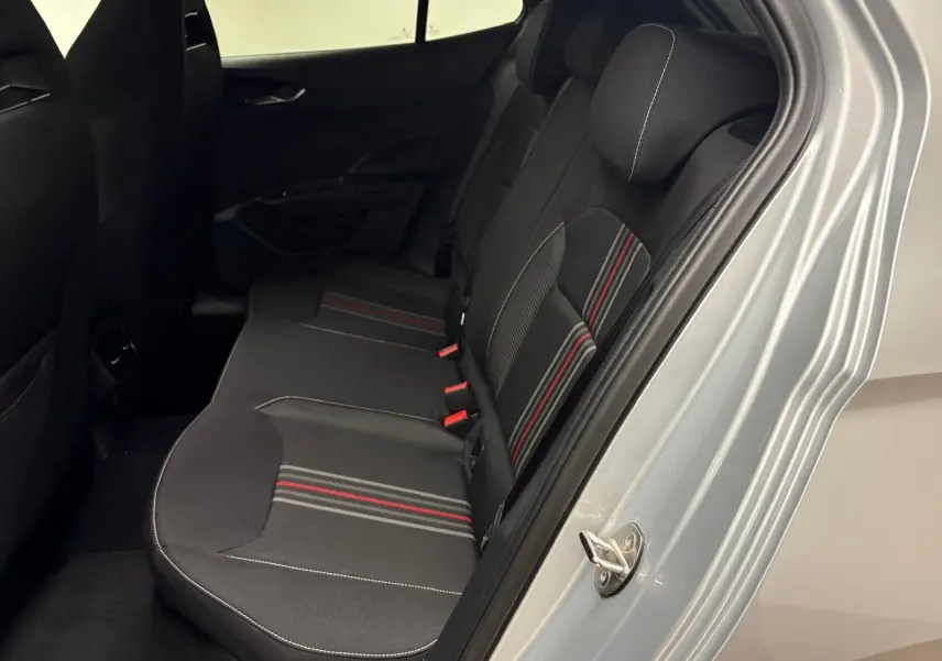 Vue intérieure côté droit des sièges arrière noirs avec surpiqûres blanches et bandes rouges sur une Skoda Fabia gris argent 2025.