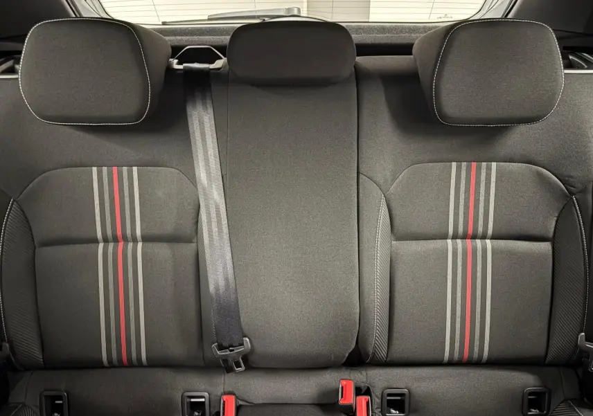 Vue intérieure des sièges arrière de la Skoda Fabia 2025, tissu gris avec bandes rouges et grises centrales.