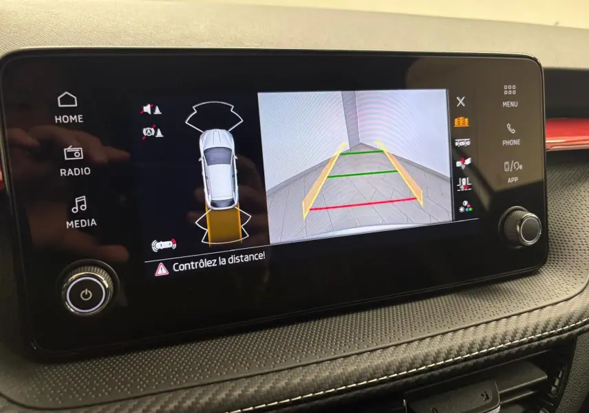 Écran central de la Skoda Fabia 2025 montrant la caméra de recul avec guidage dynamique et alertes de distance.