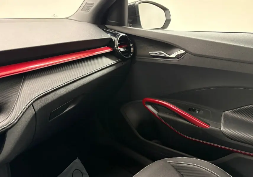 Intérieur côté passager de la Skoda Fabia Monte Carlo 2025 avec garnitures noires et inserts rouges contrastants.