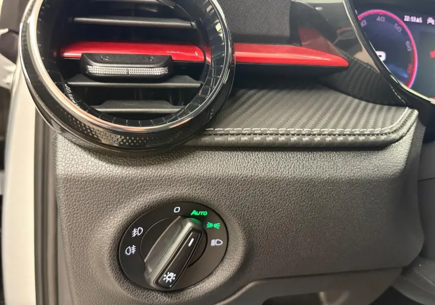 Gros plan sur la commande des phares et la sortie d’air avec insert rouge du tableau de bord de la Skoda Fabia Monte Carlo 2025.