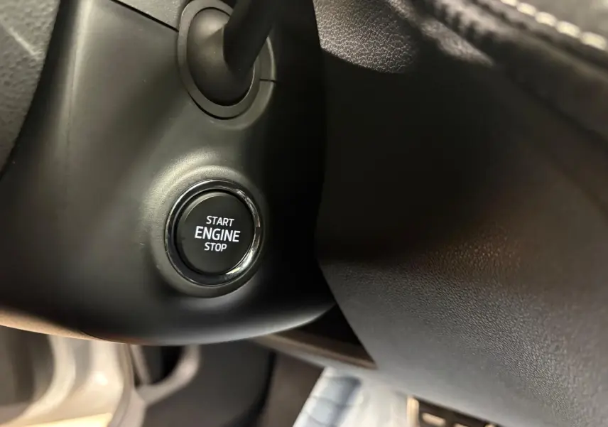 Gros plan sur le bouton Start Engine Stop du tableau de bord d'une Skoda Fabia 2025, intérieur noir.