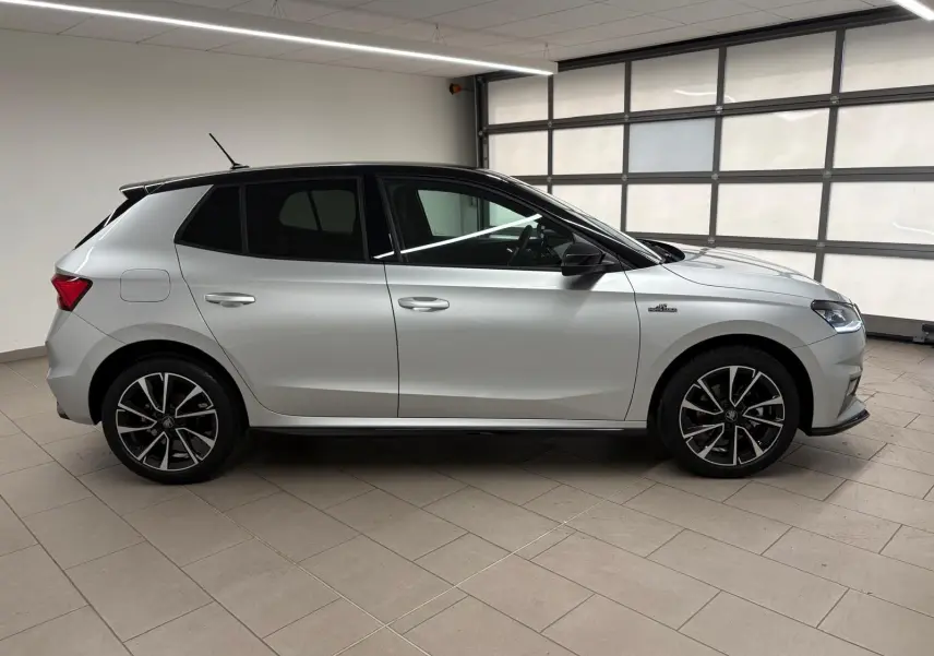 Vue de profil côté gauche de la Skoda Fabia 1.0 TSI Monte Carlo gris argent avec toit noir et jantes noires.