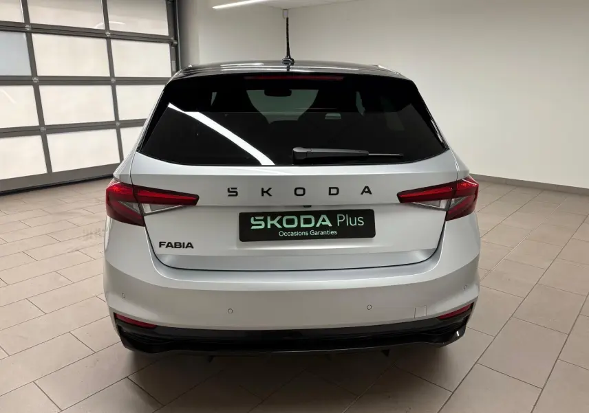 Vue arrière d'une Skoda Fabia 2025 gris argent avec toit noir, feux arrière LED et logo SKODA bien visible.