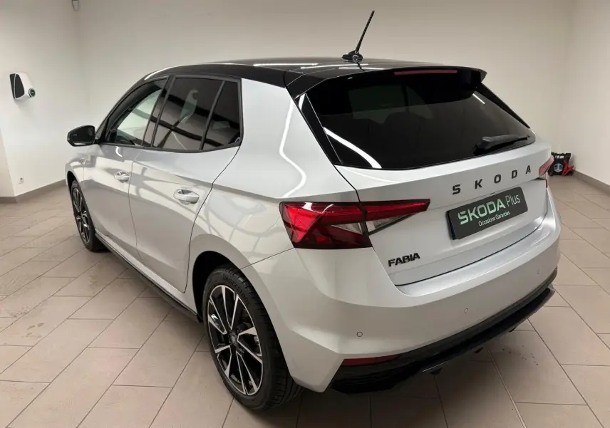 Vue 3/4 arrière droite d'une Skoda Fabia 2025 gris argent avec toit noir et jantes alliage noires.