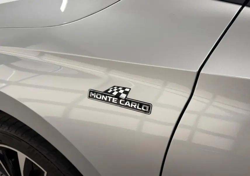Gros plan sur l'aile avant droite gris argent d'une Skoda Fabia Monte Carlo avec logo distinctif noir et damier.
