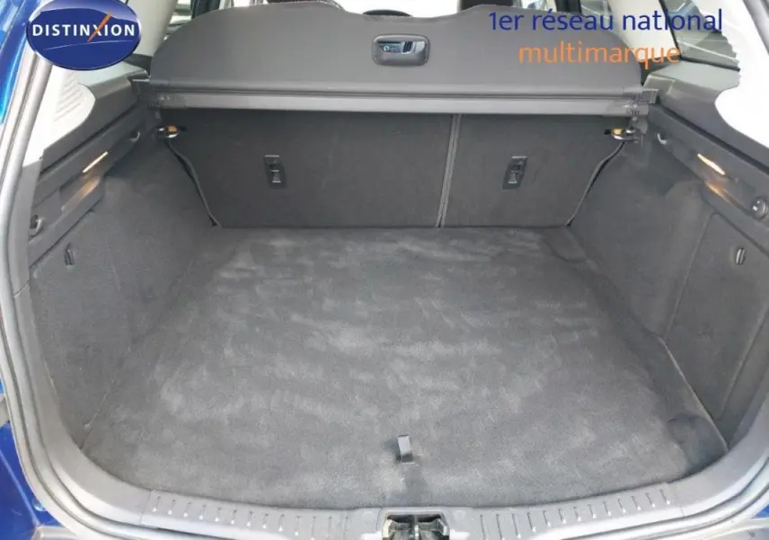 Coffre ouvert d’une Ford Focus SW bleu foncé 2018, montrant un espace de chargement propre et spacieux.