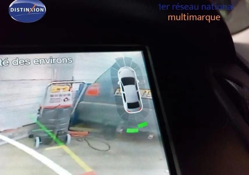 Vue de l'écran intérieur montrant l'aide au stationnement arrière d'une Ford Focus SW bleu foncé.