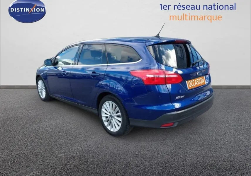 Ford Focus SW bleu foncé vue 3/4 arrière droit avec vitres surteintées et jantes alliage 17 pouces.