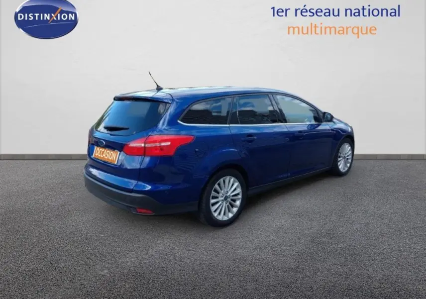 Ford Focus SW bleu foncé vue 3/4 arrière droit, vitres surteintées et jantes alliage 17 pouces visibles.