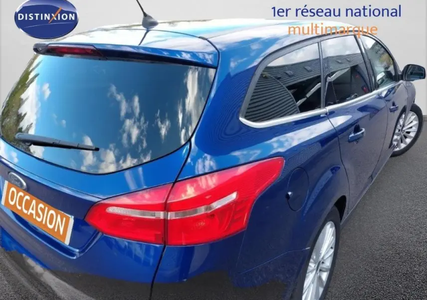 Vue 3/4 arrière droite d'une Ford Focus SW bleu foncé avec vitres surteintées et jantes alliage 17 pouces.