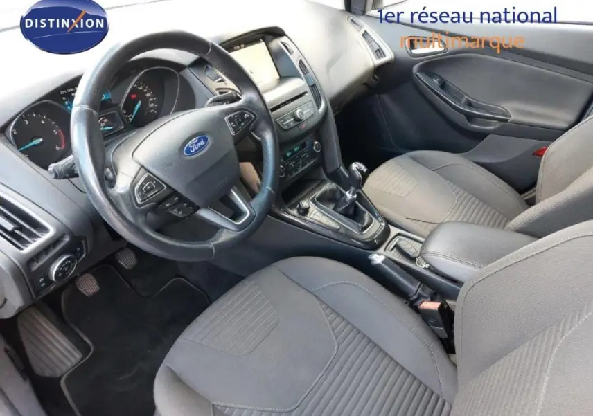 Vue intérieure avant droite de la Ford Focus SW 2018, montrant le volant, la console centrale et les sièges gris.