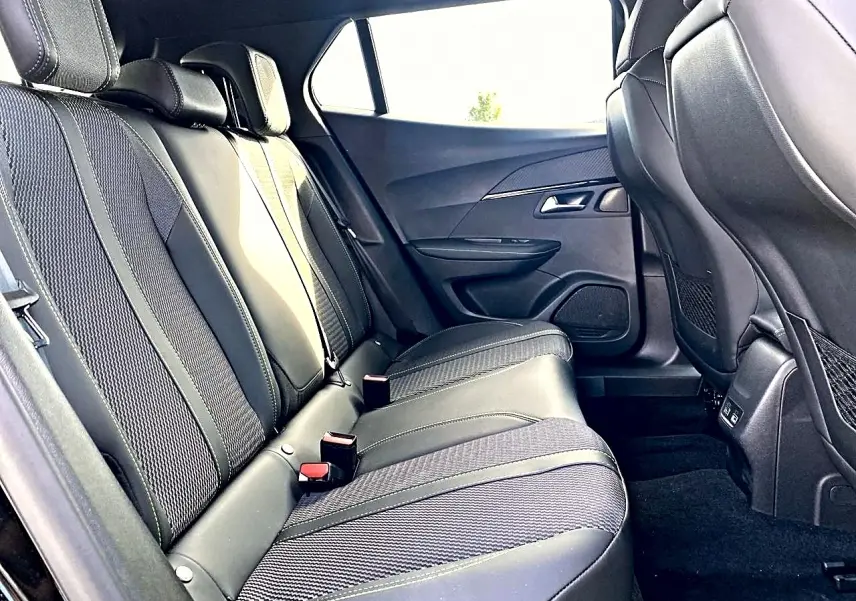 Vue latérale droite de la banquette arrière noire avec sellerie mixte cuir et tissu du Peugeot 2008 1.2 hybrid 145 GT.