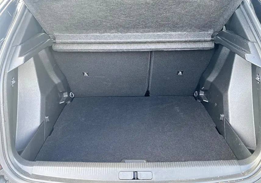 Coffre ouvert vu de l'arrière d'un Peugeot 2008 noir, montrant un espace de chargement propre et spacieux.