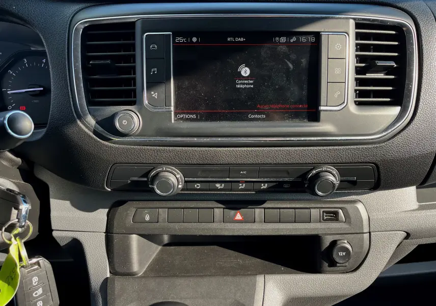 Tableau de bord du Citroën Jumpy Spacetourer 2022, écran tactile central avec commandes climatisation et prise 12V visibles.