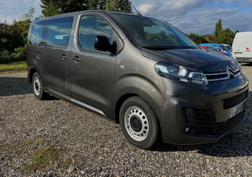 Vue 3/4 avant droit d'un Citroën Jumpy Spacetourer gris métallisé 2022 avec jantes acier et 9 places.