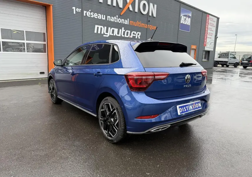 Volkswagen Polo bleu récif métallisé vue 3/4 arrière droit avec jantes alliage et vitres surteintées.