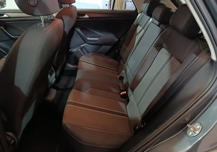 Vue intérieure côté droit sur la banquette arrière noire du Volkswagen T-Roc gris foncé, avec ceinture et appuie-têtes visibles.
