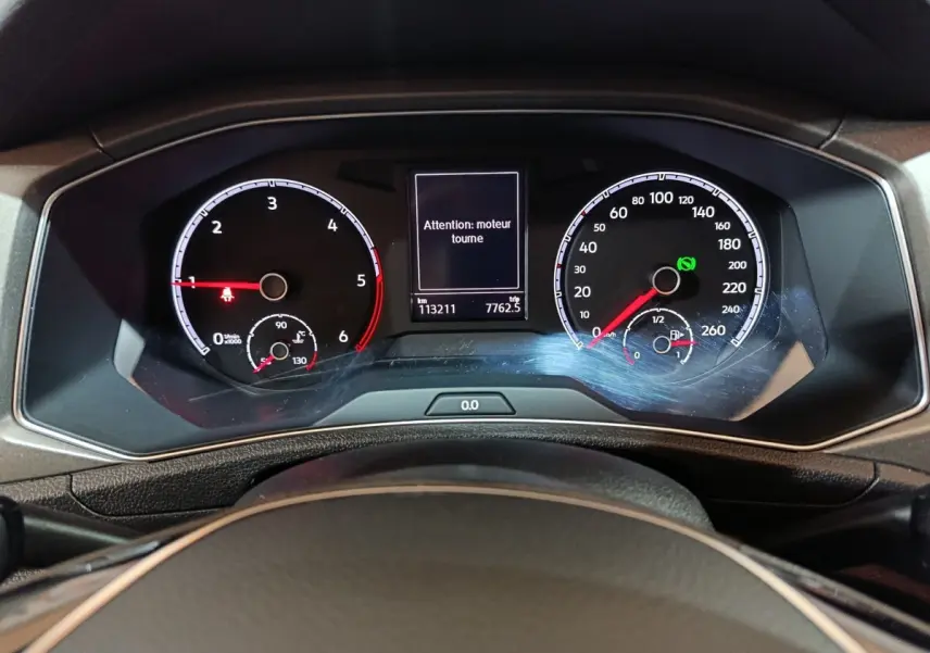 Vue rapprochée du tableau de bord digital du Volkswagen T-Roc 2021, affichant le compteur et un message moteur.