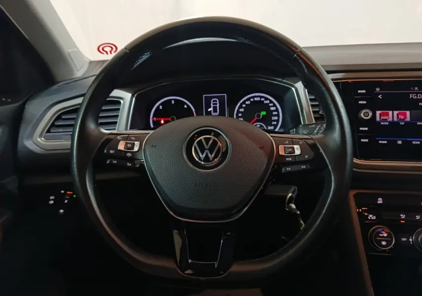Vue rapprochée du volant cuir noir et du tableau de bord digital du Volkswagen T-Roc gris foncé 2021.