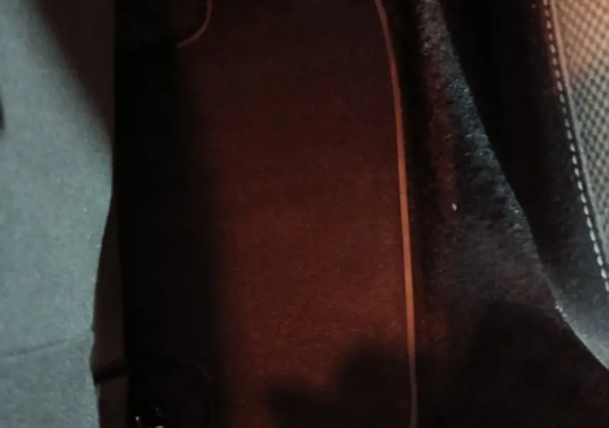 Détail du tapis de sol noir côté passager arrière du Volkswagen T-Roc gris foncé, intérieur sombre.