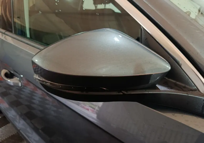 Rétroviseur côté gauche gris foncé du Volkswagen T-Roc 2.0 TDI 150 Lounge Business, avec clignotant intégré.