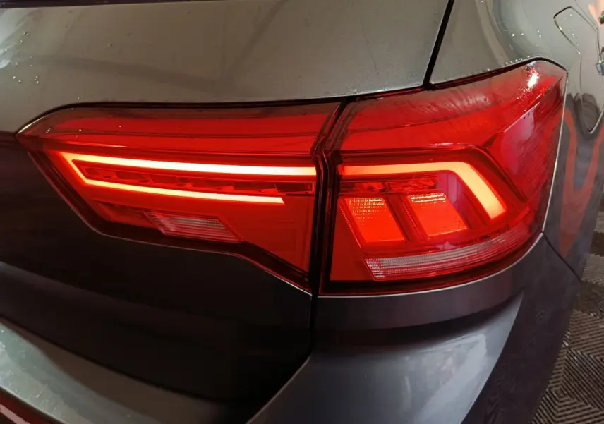 Gros plan sur le feu arrière droit rouge du Volkswagen T-Roc gris foncé, mettant en valeur son design LED moderne.