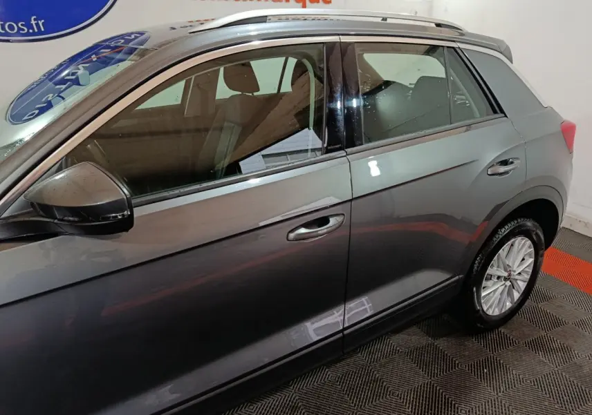 Vue latérale droite d’un Volkswagen T-Roc gris foncé, mettant en valeur les vitres teintées et les jantes alliage.
