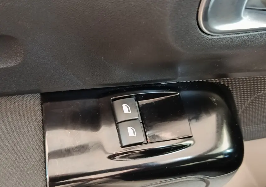 Gros plan sur les commandes de lève-vitres électriques côté conducteur d'une Citroën C3 blanche de 2020.