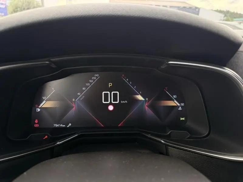 Vue rapprochée du tableau de bord numérique du DS7 Crossback blanc, affichant la vitesse à 0 km/h et divers indicateurs.
