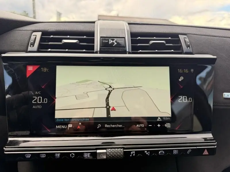 Vue rapprochée de l’écran tactile central du DS7 Crossback blanc 2019 affichant la navigation et la climatisation à 20°C.