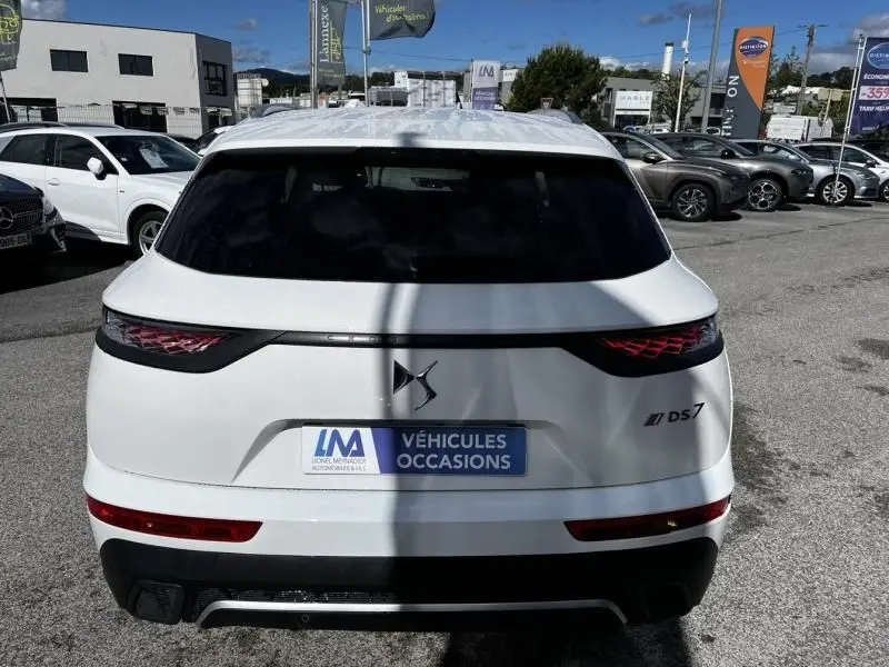 Vue arrière d'un DS7 Crossback blanc 2019 avec feux arrière distinctifs et logo DS, stationné en extérieur.