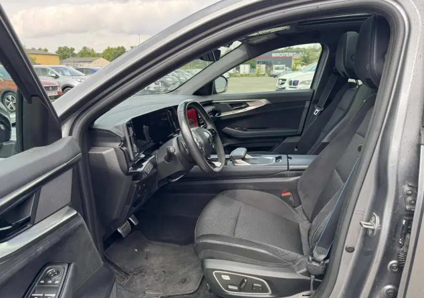 Intérieur côté conducteur du Renault Austral gris 2023, avec sièges sport, volant multifonctions et écran tactile visible.