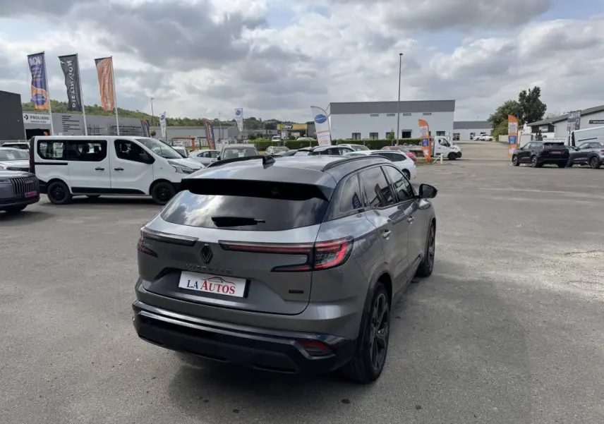 Vue 3/4 arrière droite d'un Renault Austral gris avec vitres surteintées et jantes aluminium noires.