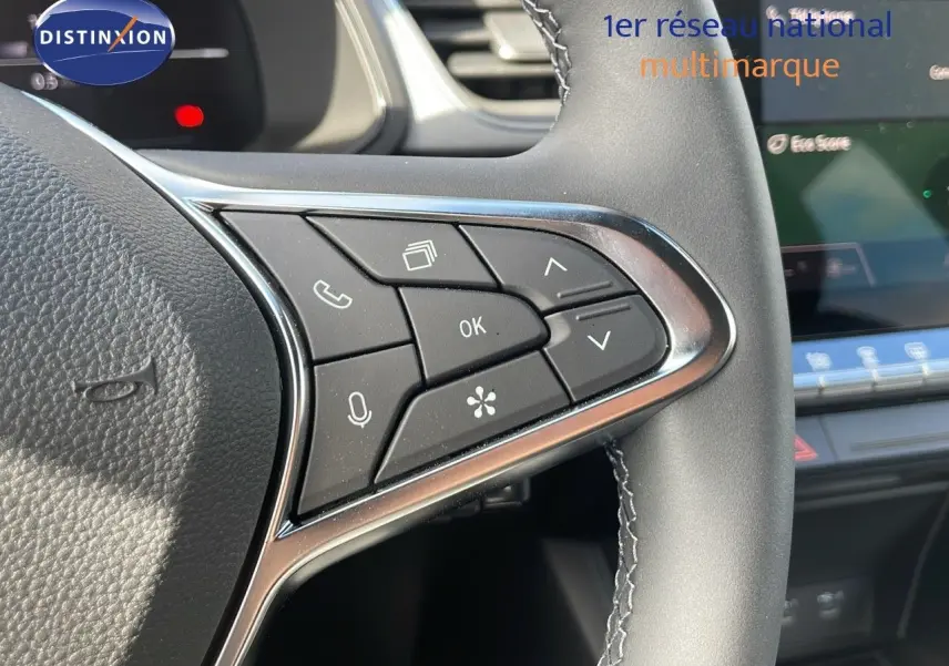 Gros plan sur les commandes multifonctions à droite du volant du Renault Captur 2025, finition noire avec surpiqûres grises.